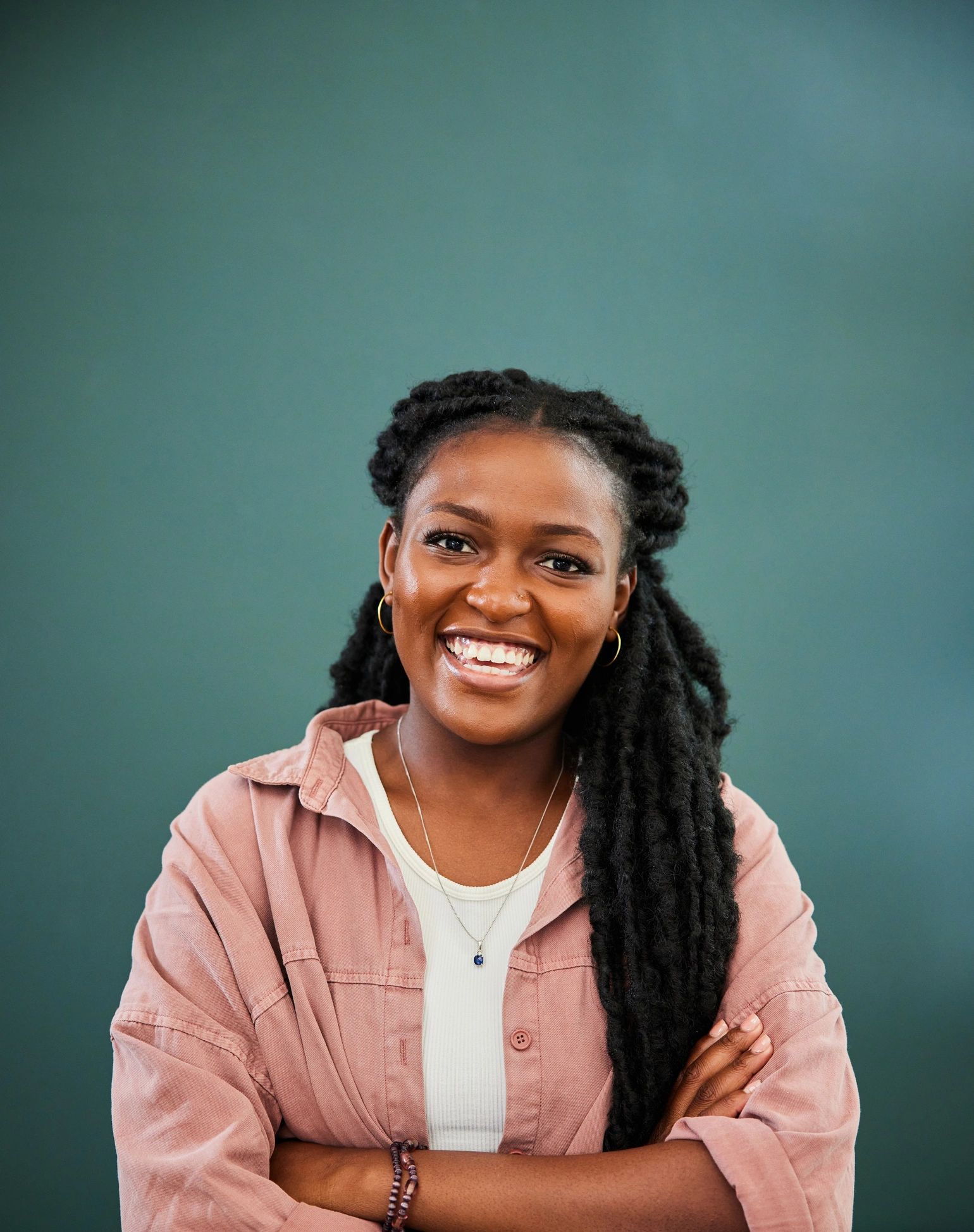 Portrait of a community organizer smiling against a green wall