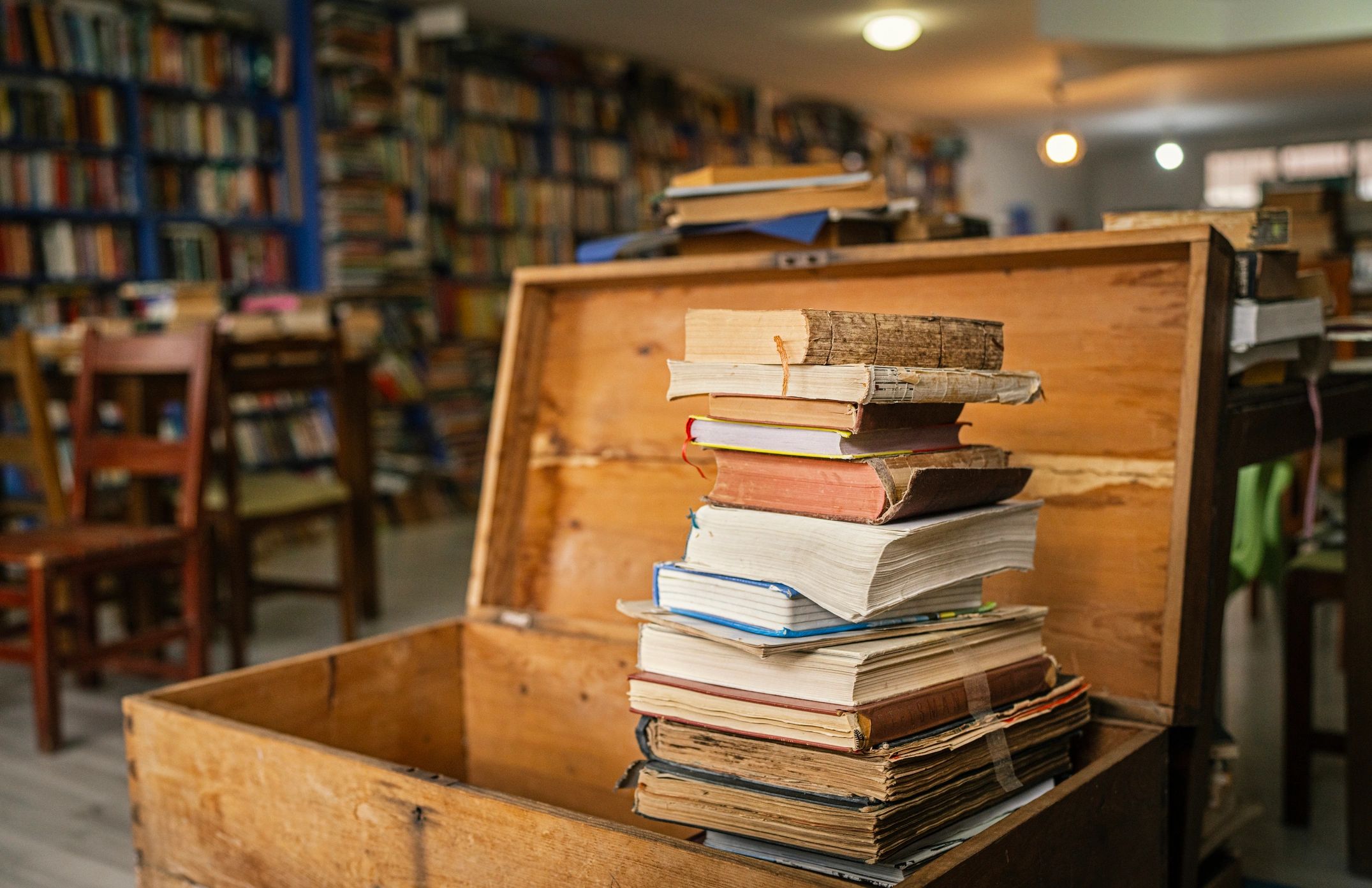 Stack of antique books in a wooden chest